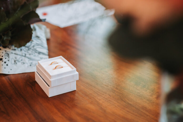 Trauringe in Schachtel auf einem schönen Holztisch